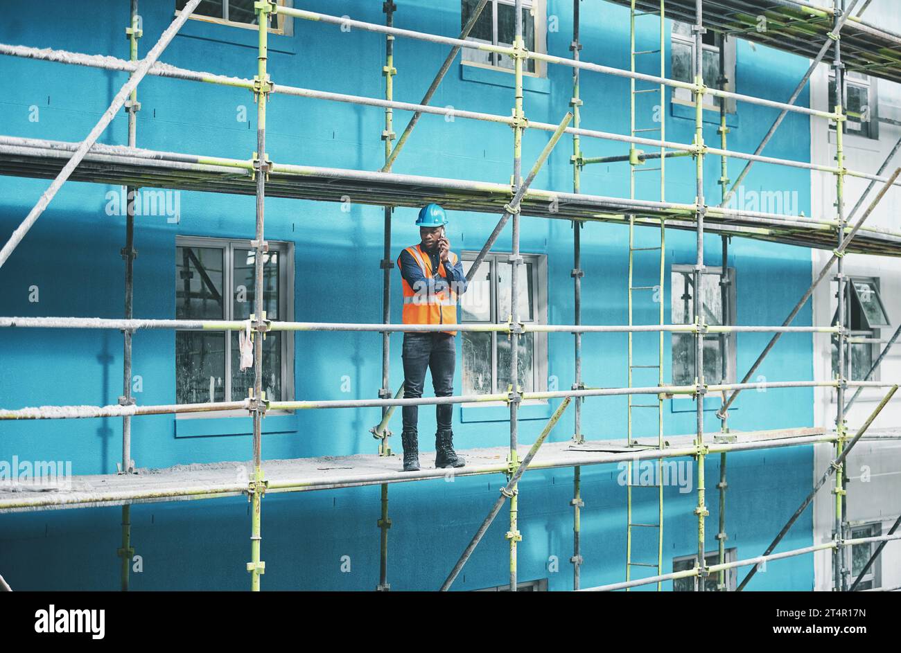 Engineers simple love solving problems. a young man talking on a cellphone while working at a construction site. Stock Photo