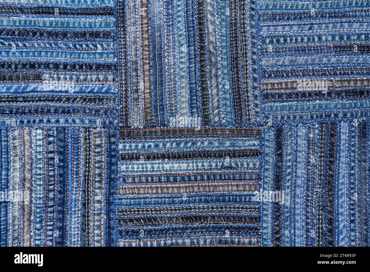 Close up view of denim fabric pattern in patchwork style, made of seams ...