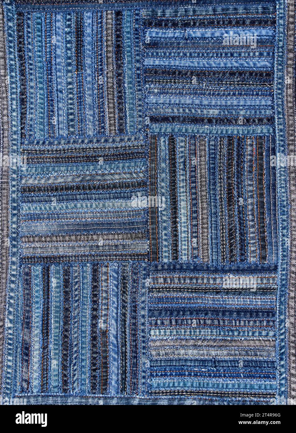 Close up view of denim fabric pattern in patchwork style, made of seams ...