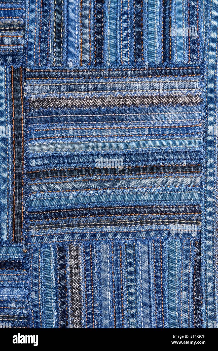 Close up view of denim fabric pattern in patchwork style, made of seams ...