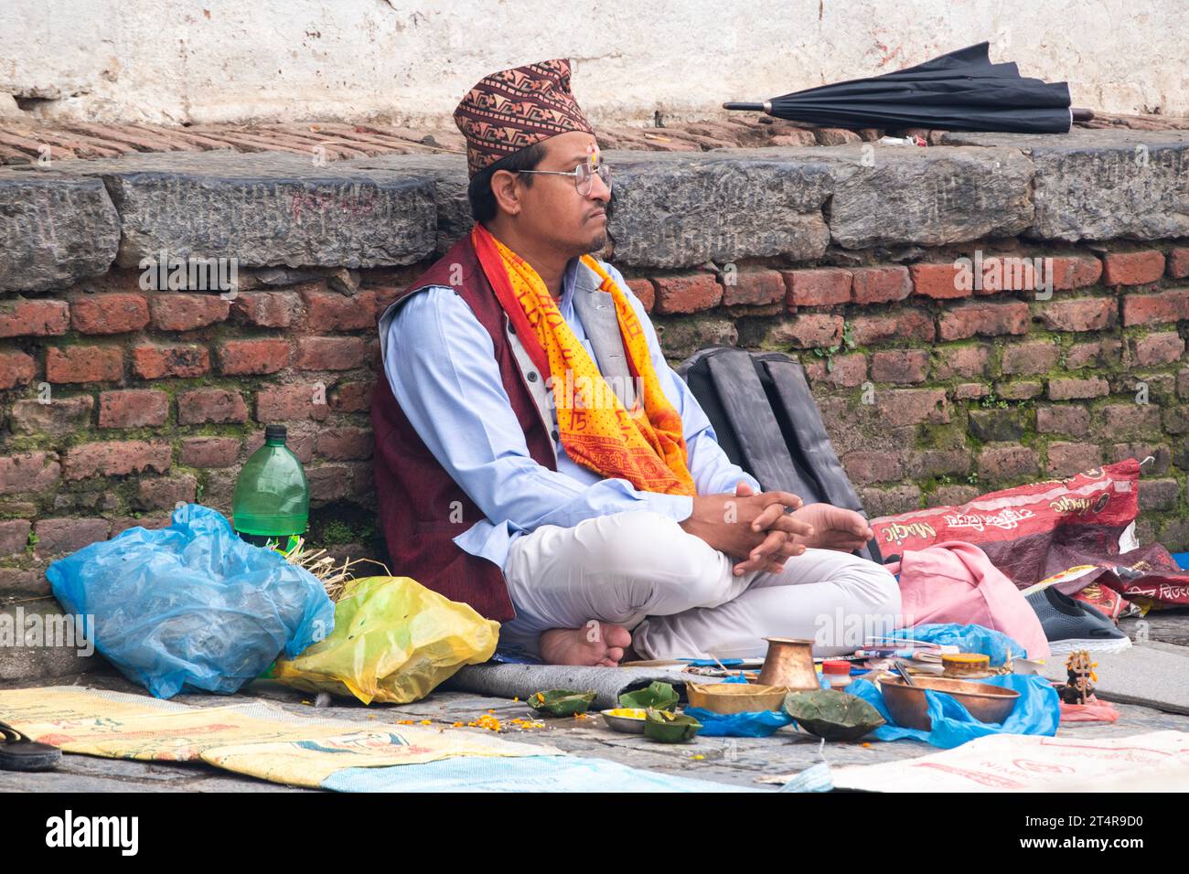 Kathmandu, Nepal: hindu guru waiting for a family to prepare gifts for the dead at Pashupatinath Temple, famous Hindu temple dedicated to Shiva Stock Photo