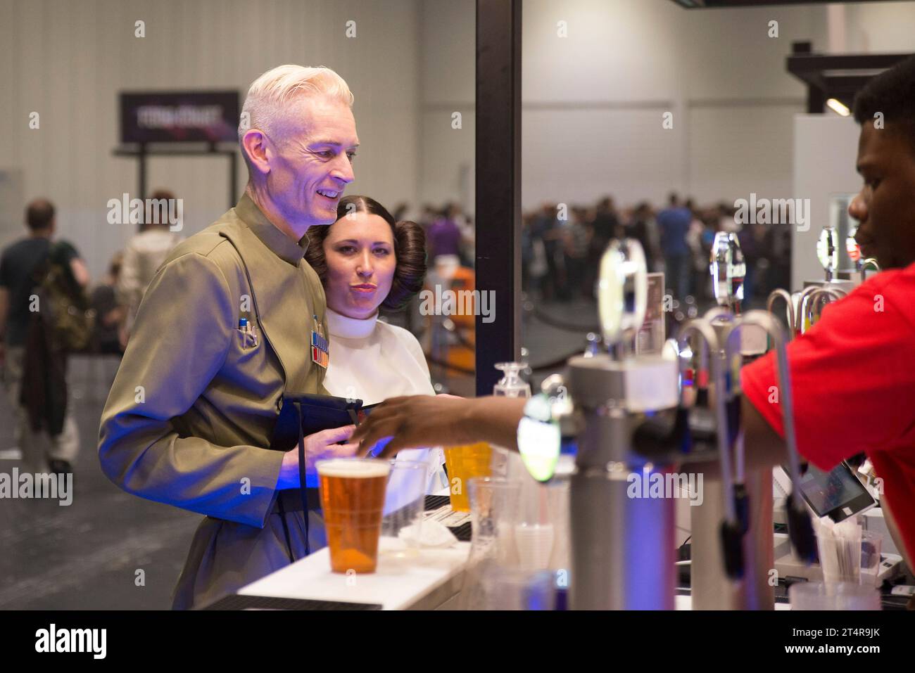 Imperial Officer and Princess Leia cosplay fans buying alcohol at a bar Stock Photo