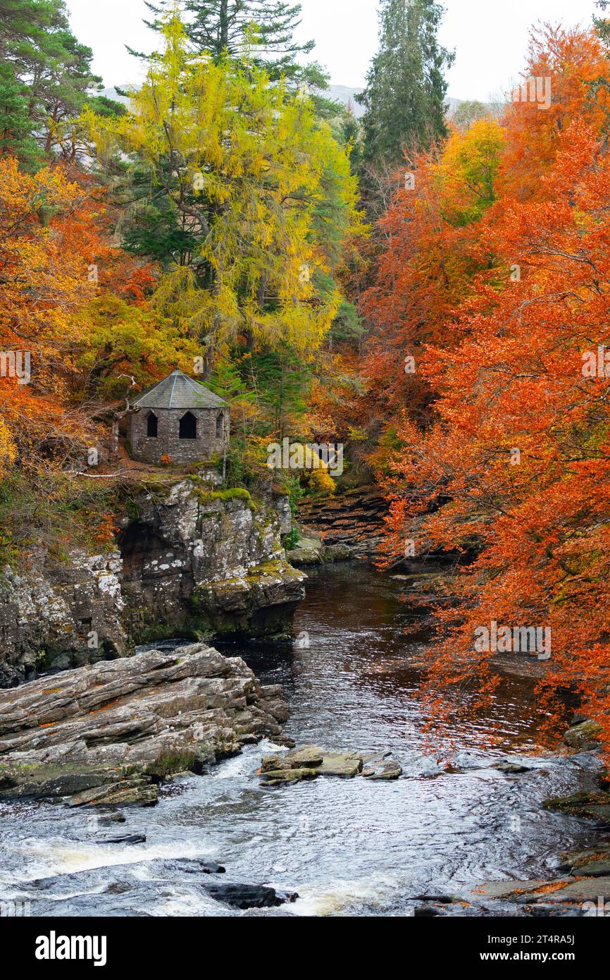 The old summer house beside River Moriston falls with autumn colours in woodland in Invermoriston, Scotland, UK Stock Photo