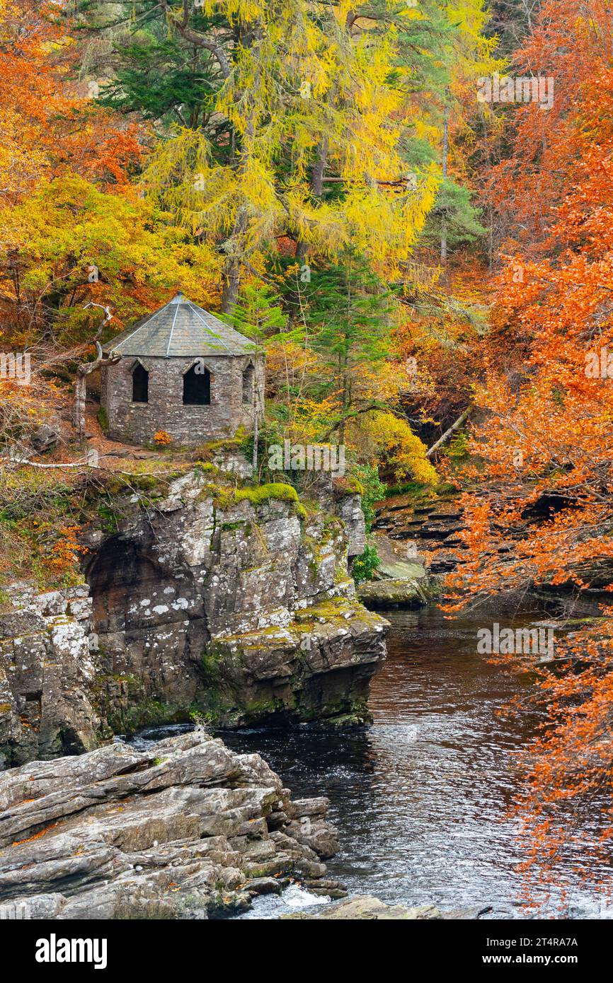 The old summer house beside River Moriston falls with autumn colours in woodland in Invermoriston, Scotland, UK Stock Photo