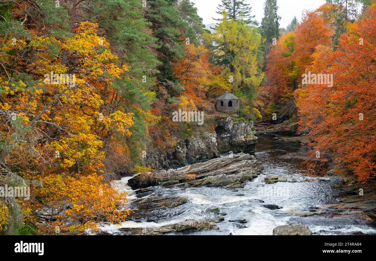 The old summer house beside River Moriston falls with autumn colours in woodland in Invermoriston, Scotland, UK Stock Photo