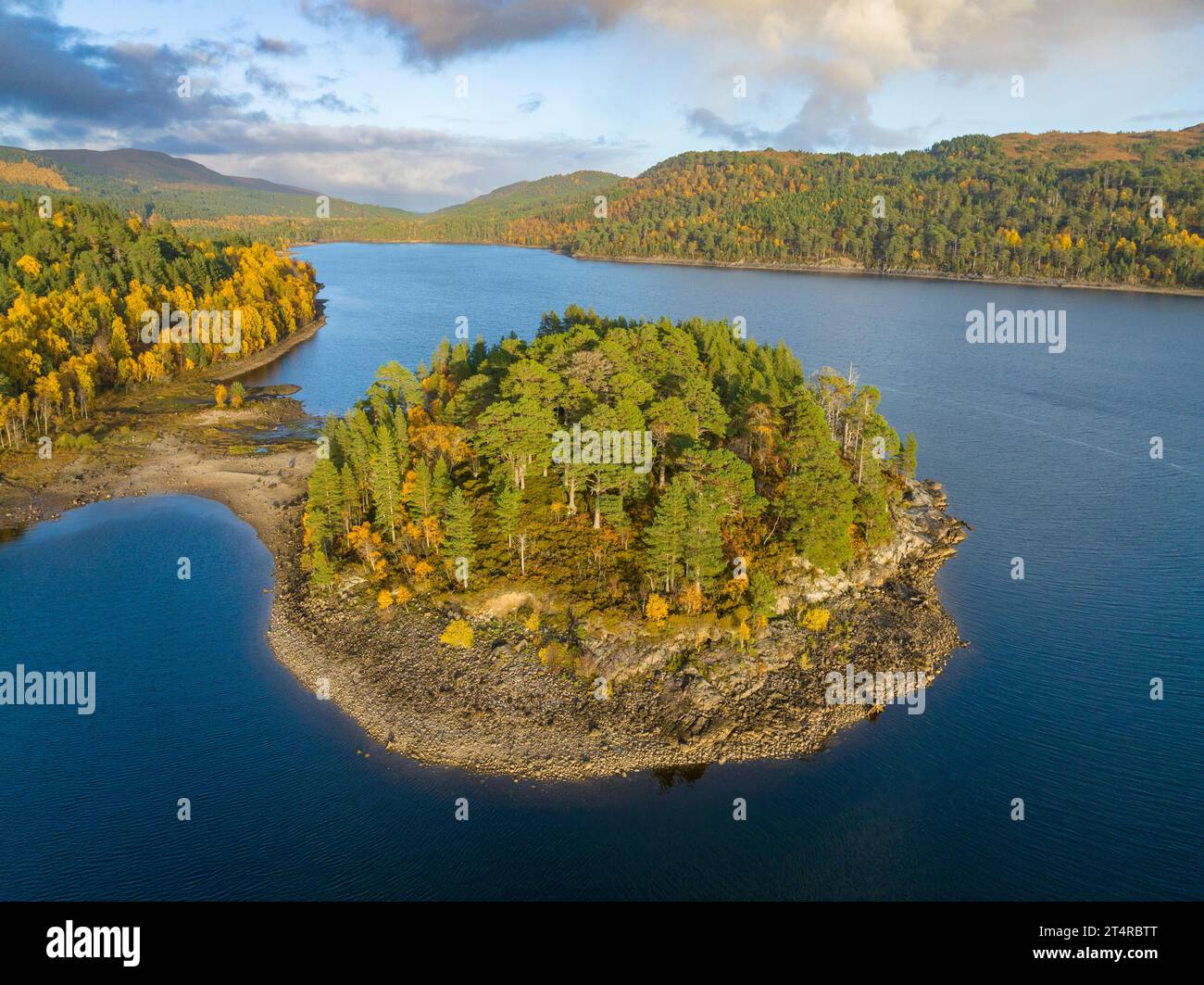 Aerial views of autumnal colours in woodland beside Loch Beinn a