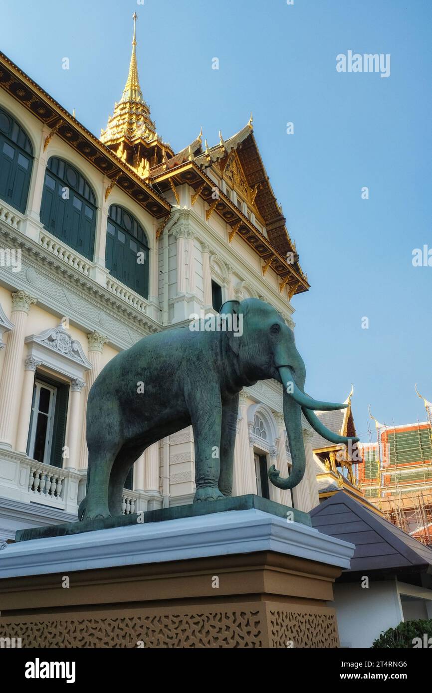 In front of a splendidly adorned building, an impressive elephant statue stands proudly on a pedestal adorned with intricate patterns. Stock Photo