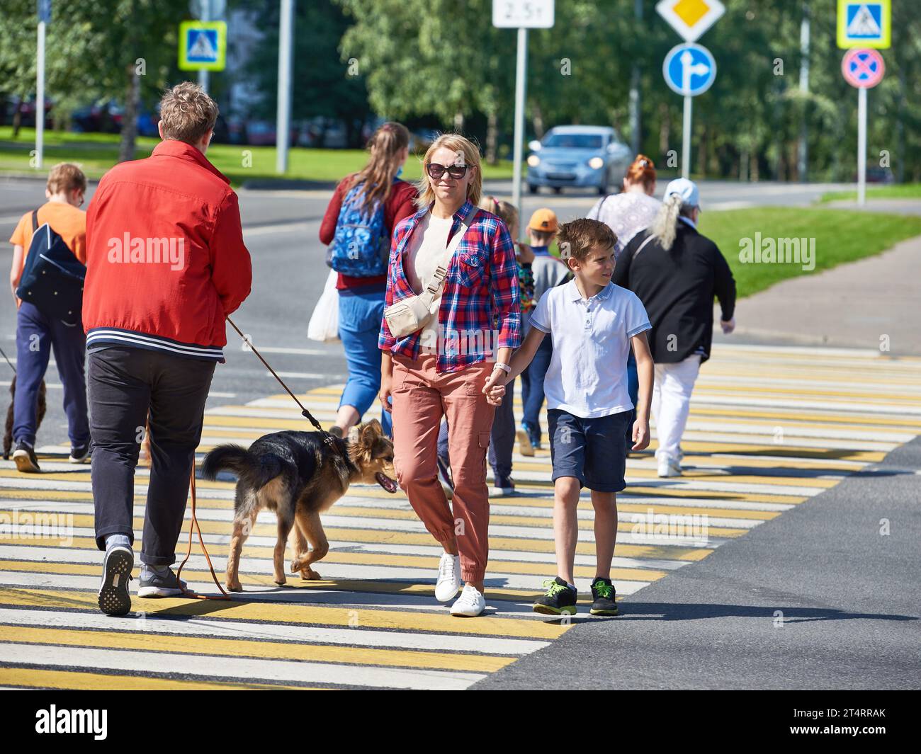 Woman and child cross the road at a pedestrian crossing Stock Photo - Alamy