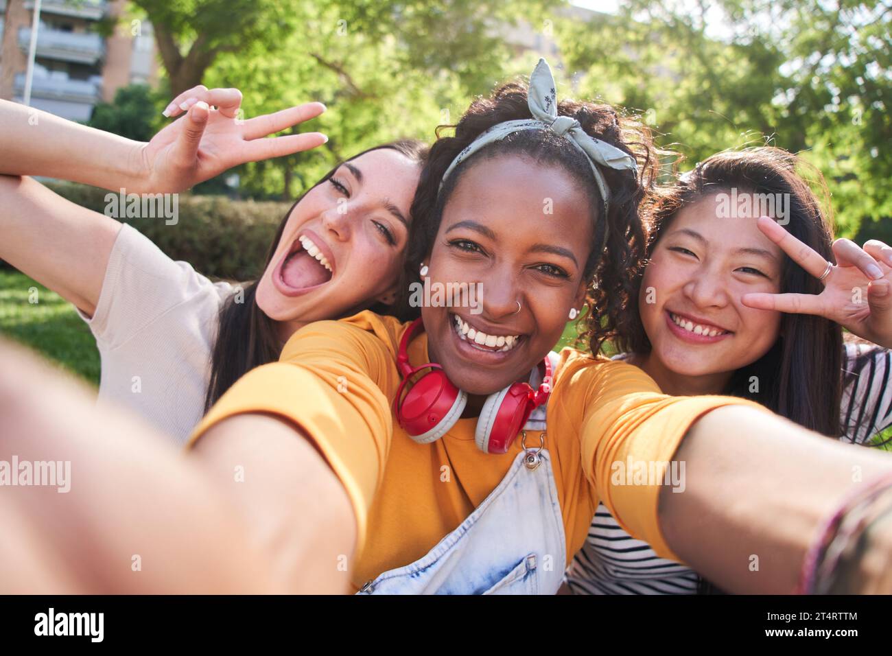 Selfie three excited multicultural cheerful young women outdoors. Attractive females having fun. Stock Photo