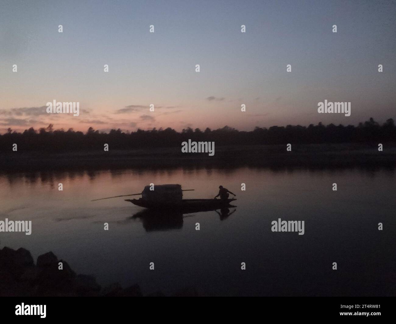 Naogaon, Bangladesh. 2nd Nov, 2023. A fisherman works on a fishing net during sunset on the Atrai River near Dhamoirhat of Naogaon district. (Credit Image: © MD Mehedi Hasan/ZUMA Press Wire) EDITORIAL USAGE ONLY! Not for Commercial USAGE! Stock Photo