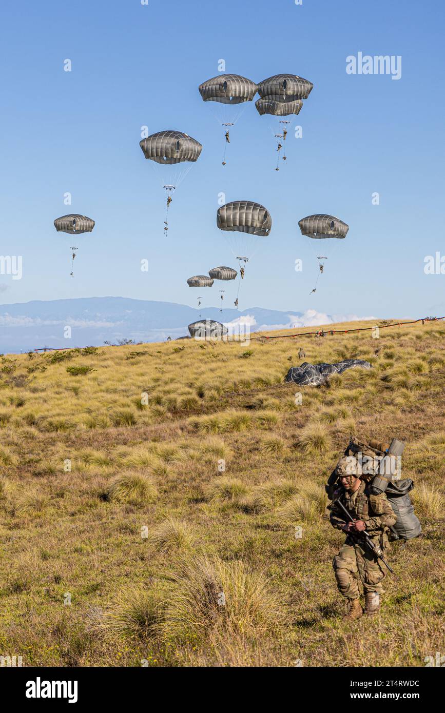 Pohakuloa Training Area, United States. 31st Oct, 2023. U.S. Army paratroopers, with the 11th Airborne Division descend in parachutes after jumping from a C-17 transport aircraft during the multinational Joint Pacific Multinational Readiness Center 24-01 at the Pohakuloa Training Area, October 31, 2023 in Mauna Loa, Hawaii. Credit: Spc. Mariah Aguilar/U.S Army/Alamy Live News Stock Photo