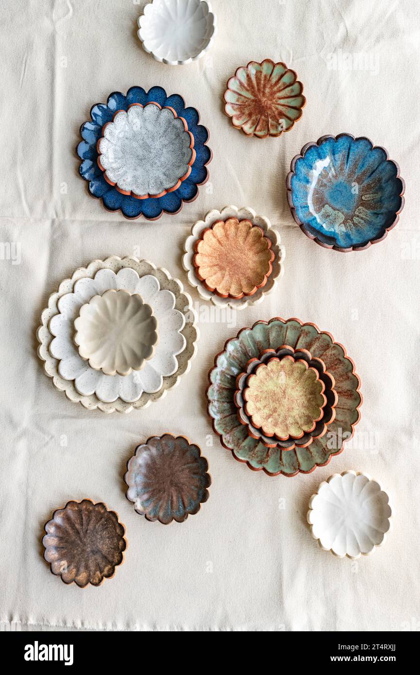 Ceramic scallop plates and bowls in various coloured glazes Stock Photo