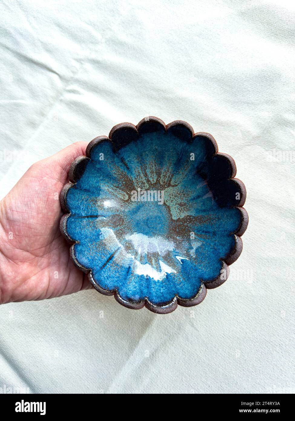 A Handmade ceramic scallop bowl in blue glaze Stock Photo