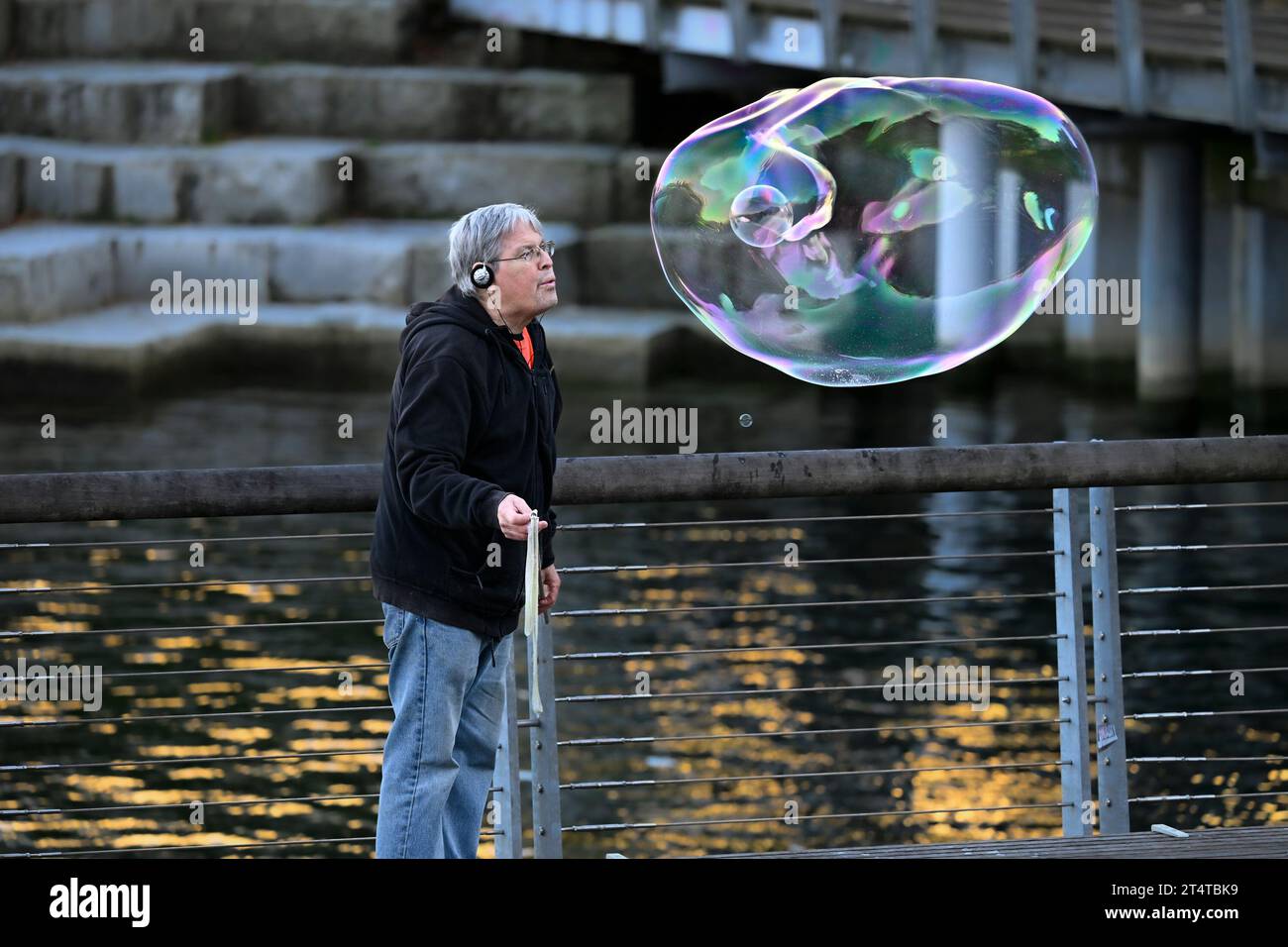 man blowing large soap bubble Stock Photo