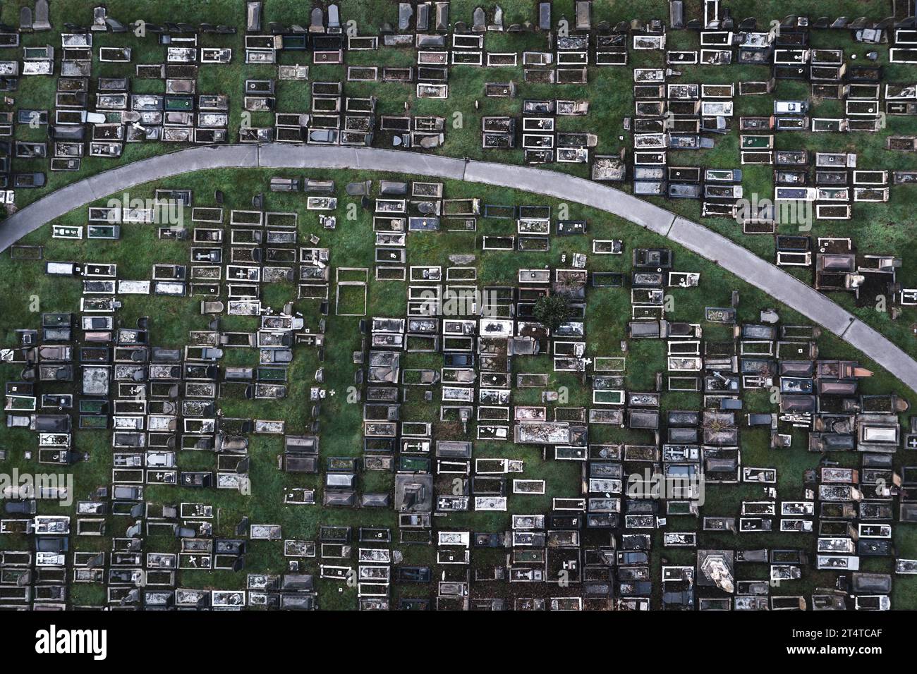 Aerial view directly above a packed inner city cemetery with rows of graves and tombstones in a grief or bereavement concept with copy space Stock Photo