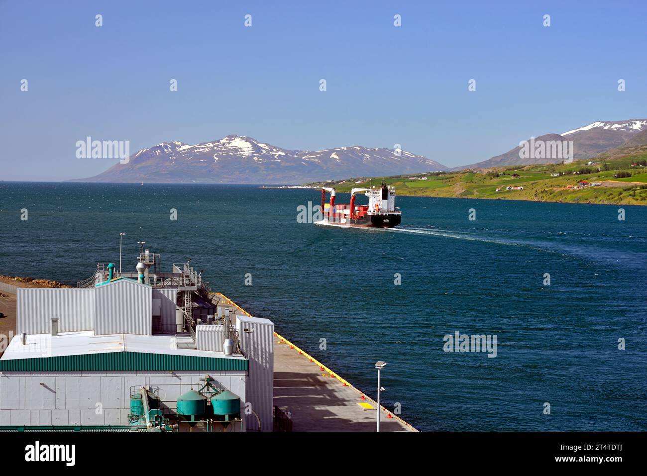 The Container Ship Selfoss is seen leaving the port of Akureyri North East Iceland after having spent the day unloading and loading containers. Stock Photo