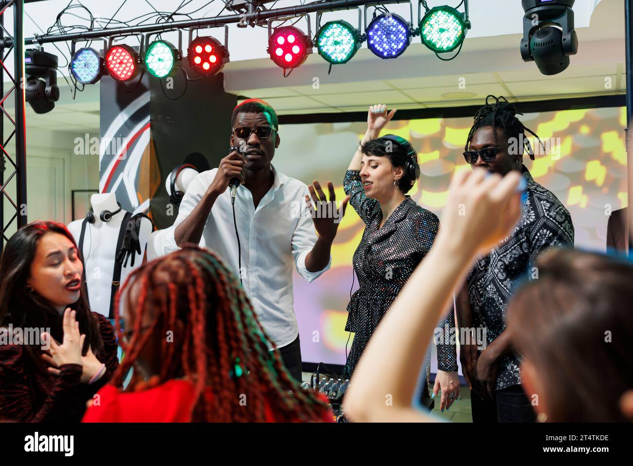 Band performing on stage with spotlights while crowd cheering and