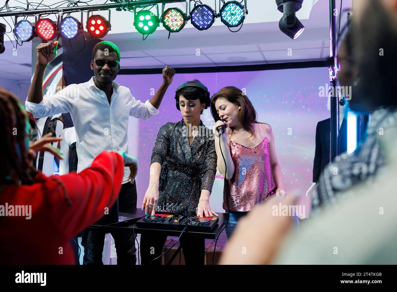 Electronic music band performing on stage with spotlights at concert in