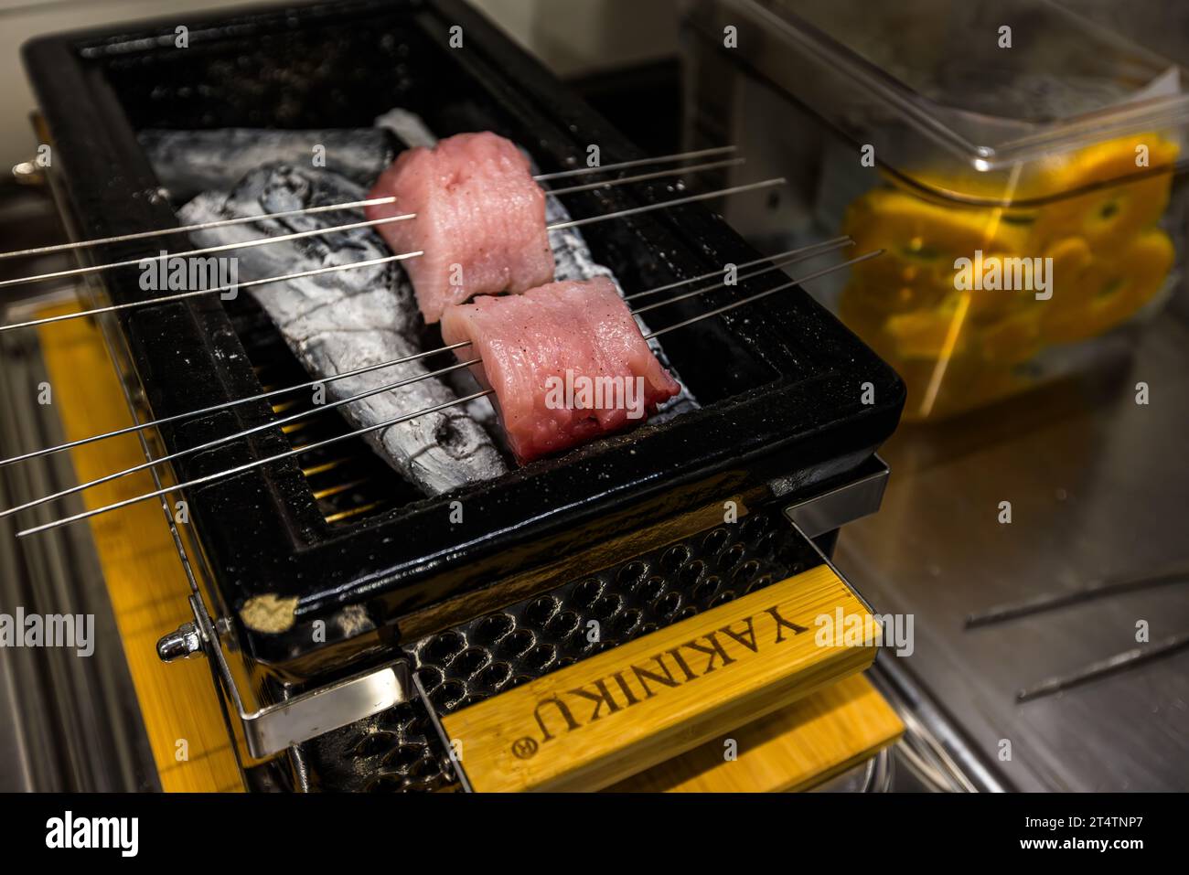 Fillets of silver carp are grilled over lychee charcoal on a Japanese table grill. Wiesau (VGem), Germany Stock Photo