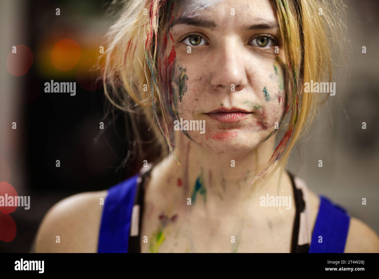 Portrait of a female artist. Girl with clumsy clorful painted face ...