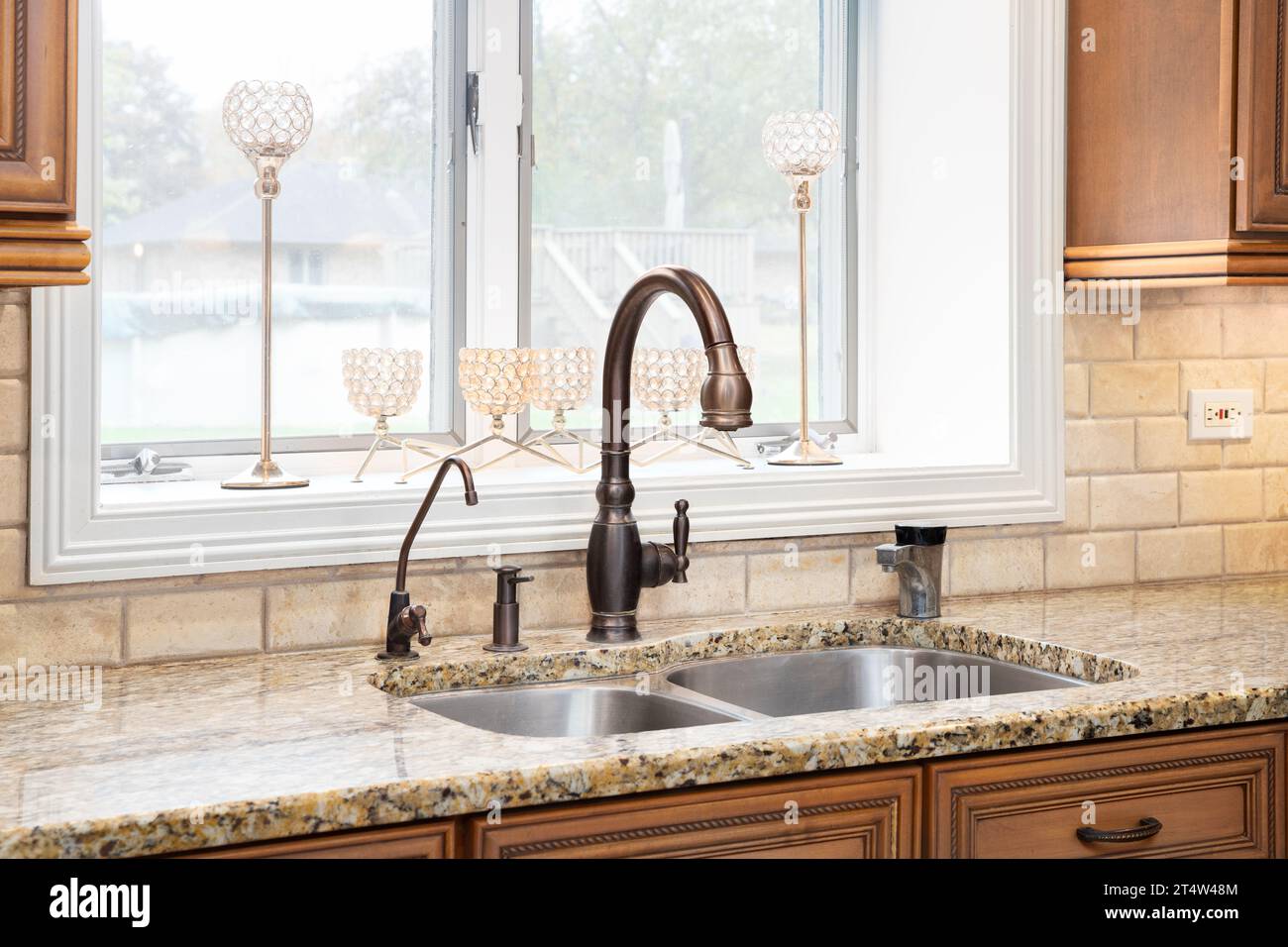 A bronze kitchen faucet detail with wood stone subway tile