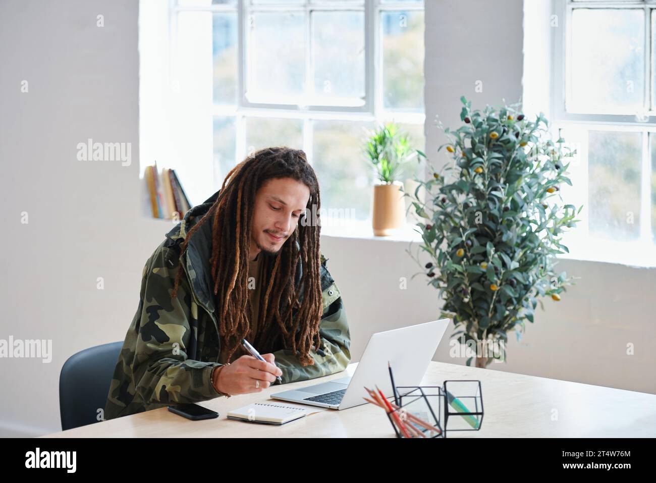 Creative man, laptop and writing on desk with notebook for information ...