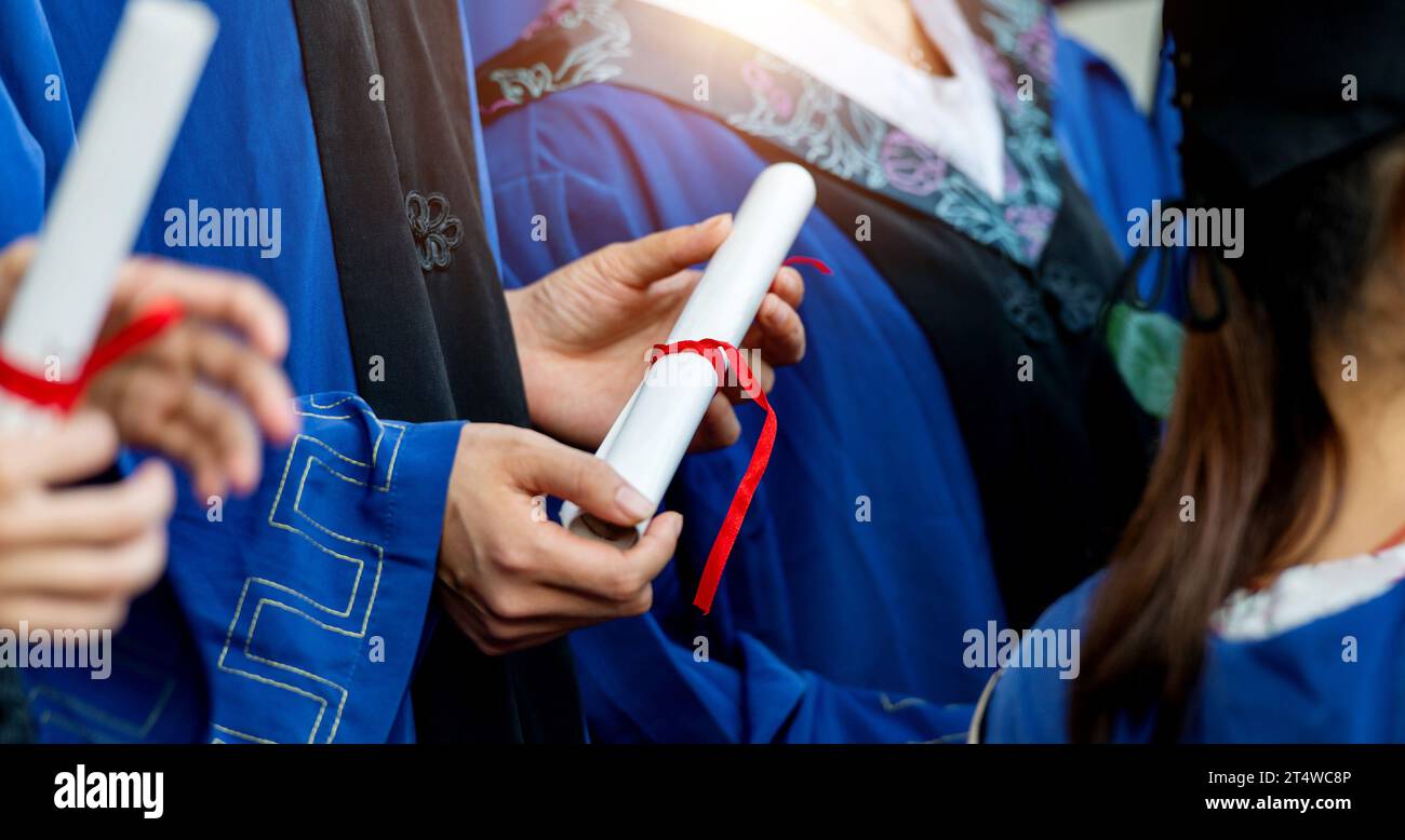 People in gowns holding a diploma Stock Photo