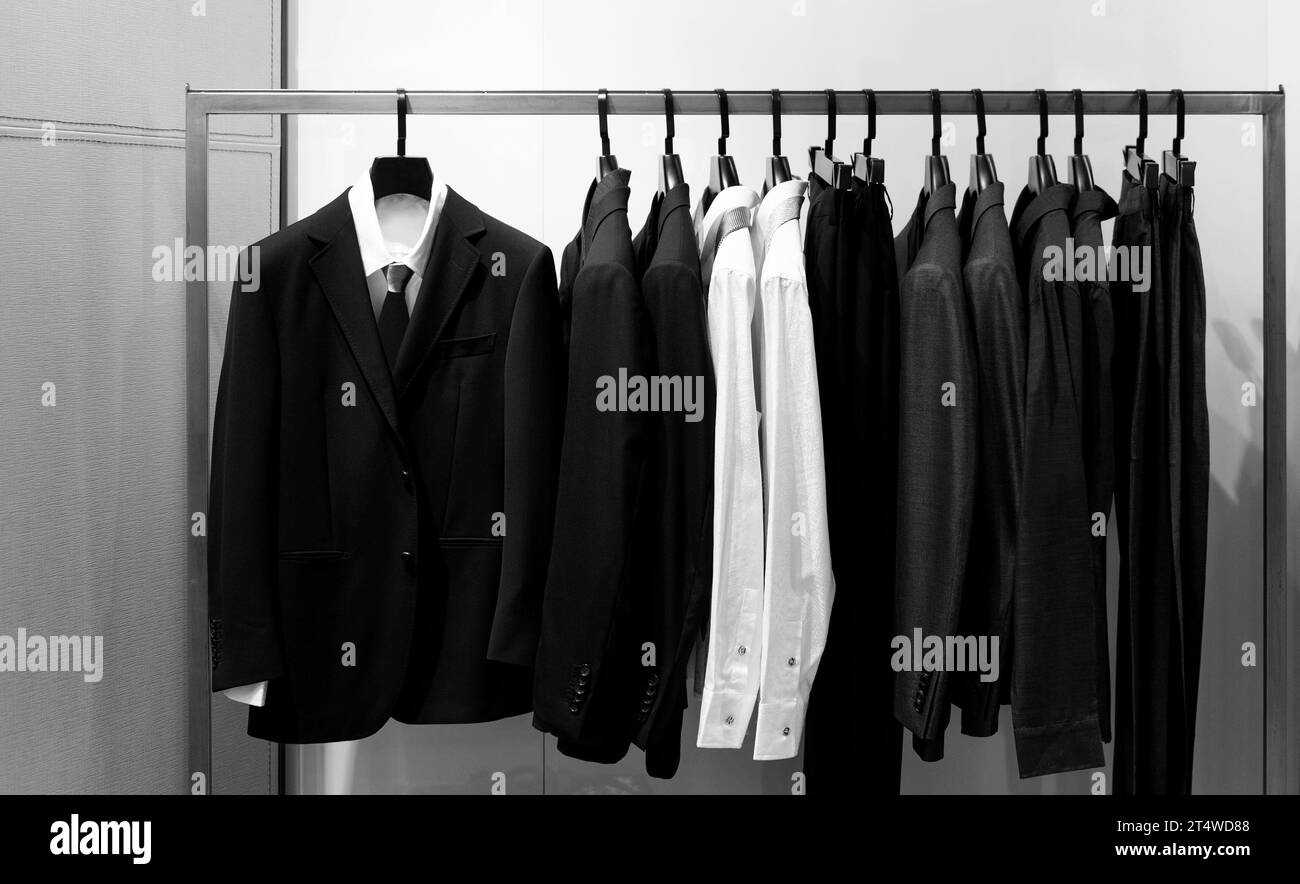 Row of men's suits hanging in closet Stock Photo