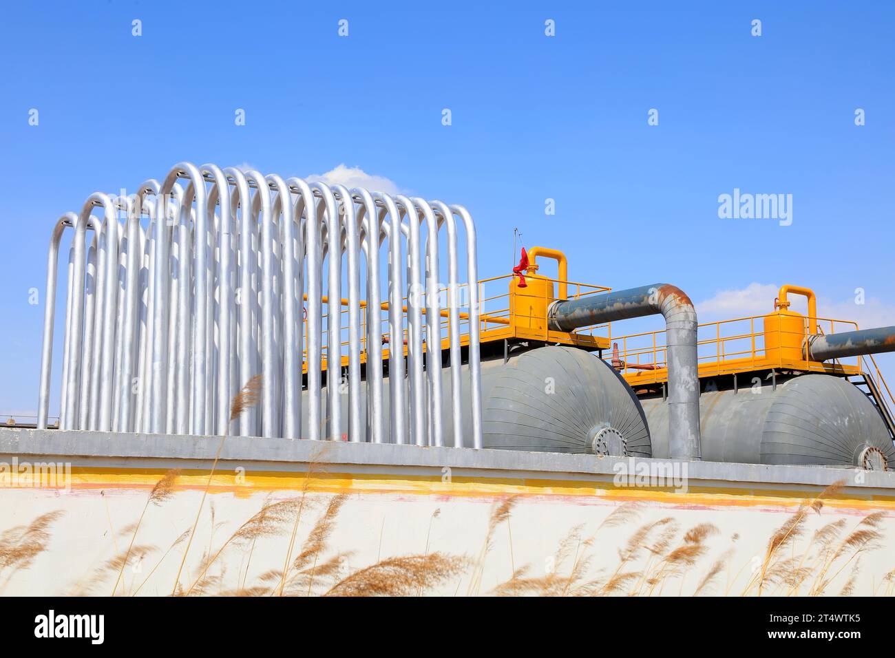 Silver metal radiator and storage tanks under blue sky Stock Photo - Alamy