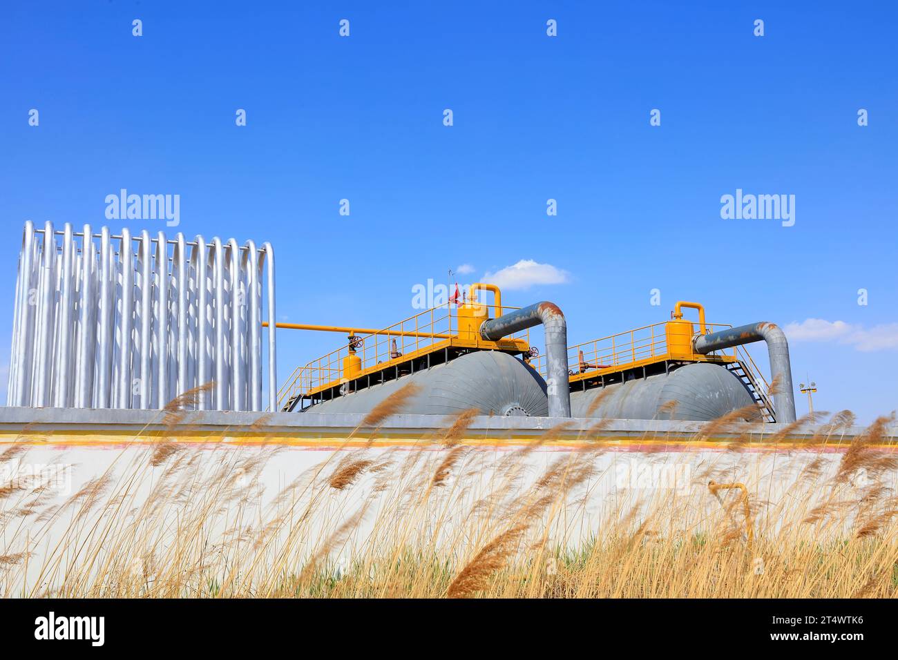 Silver metal radiator and storage tanks under blue sky Stock Photo - Alamy