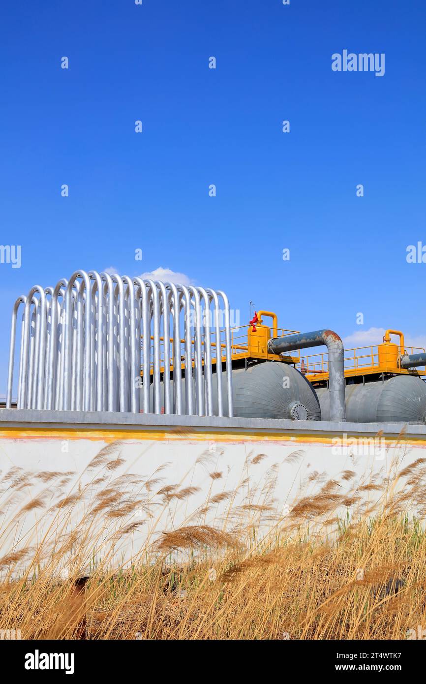 Silver metal radiator and storage tanks under blue sky Stock Photo