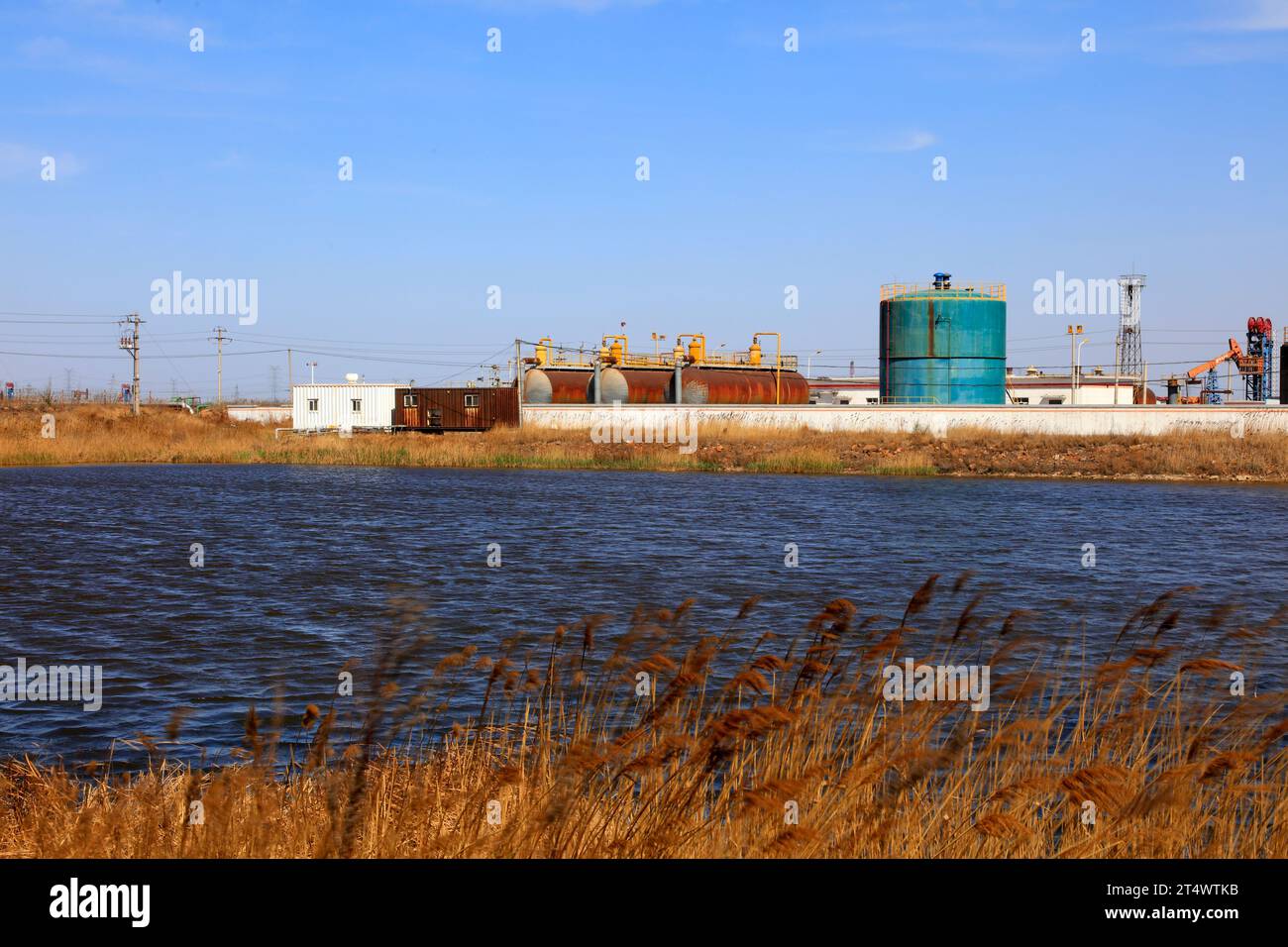 Oil storage tanks and pond under blue sky Stock Photo - Alamy