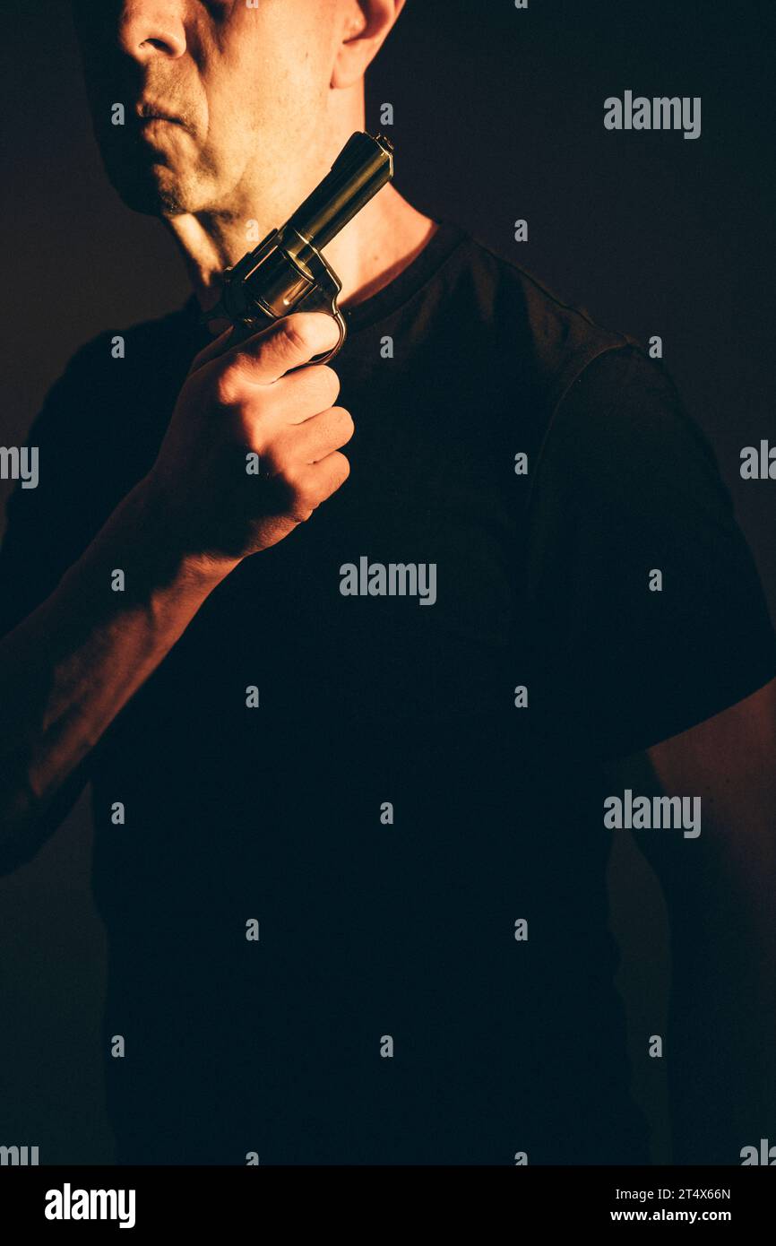 Gunman killer holding pistol artistic photo book cover design with colors and lighting. Stock Photo