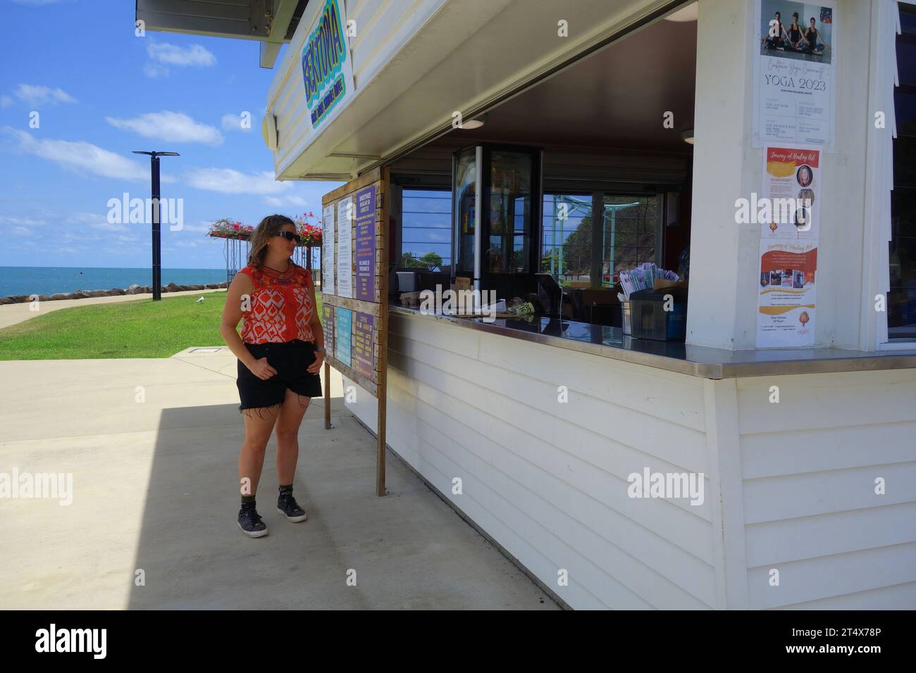 Woman waiting at Bek-Topia cafe on the Esplanade, Cooktown, southern ...