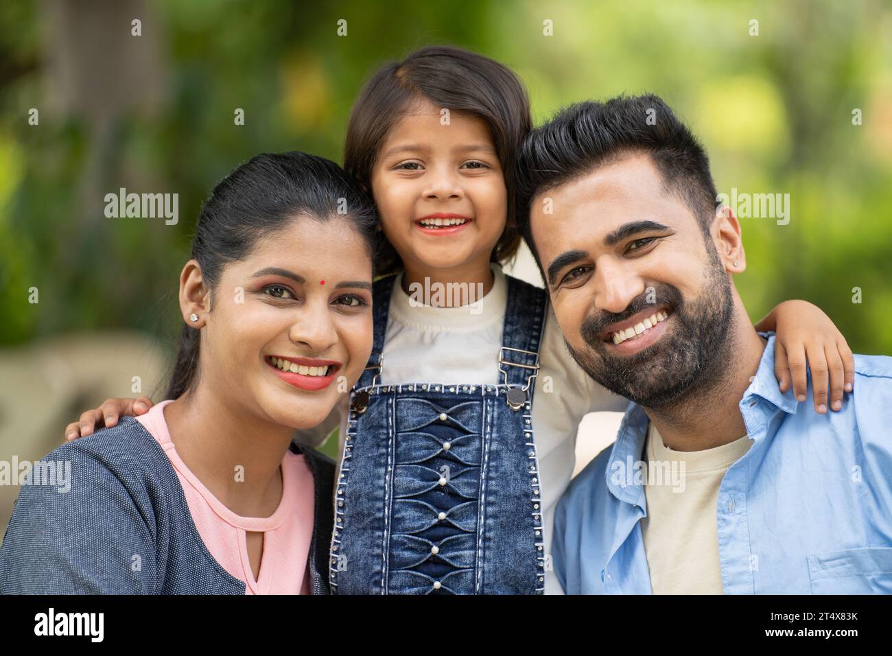 portrait shot of Happy smiling indian couple with girl kid looking ...