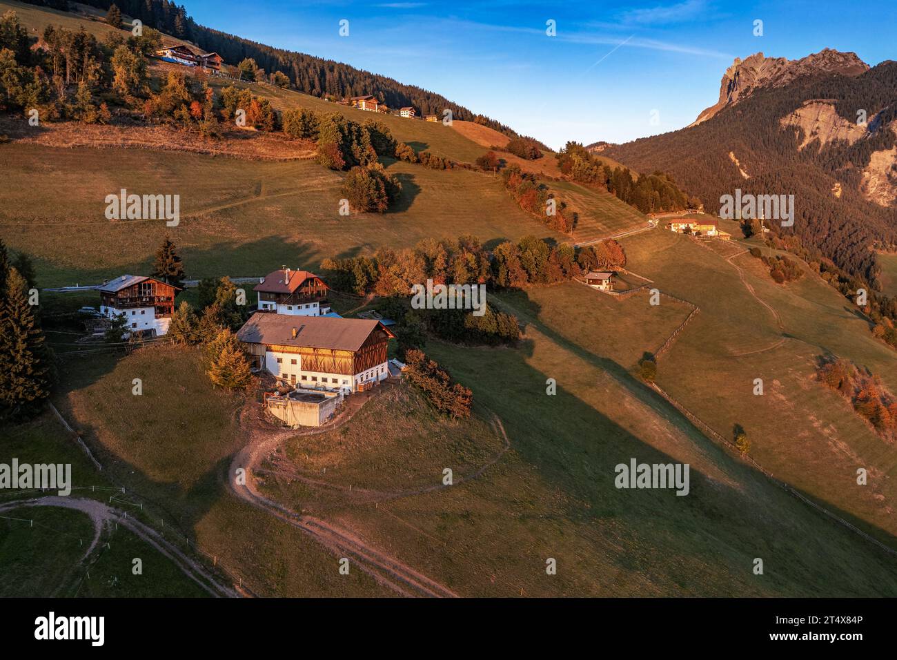 Santa Maddalena, Italy - Aerial panoramic view of Santa Maddalena village at sunset. Autumn scenery with traditional tyrolean houses, mountain peaks a Stock Photo