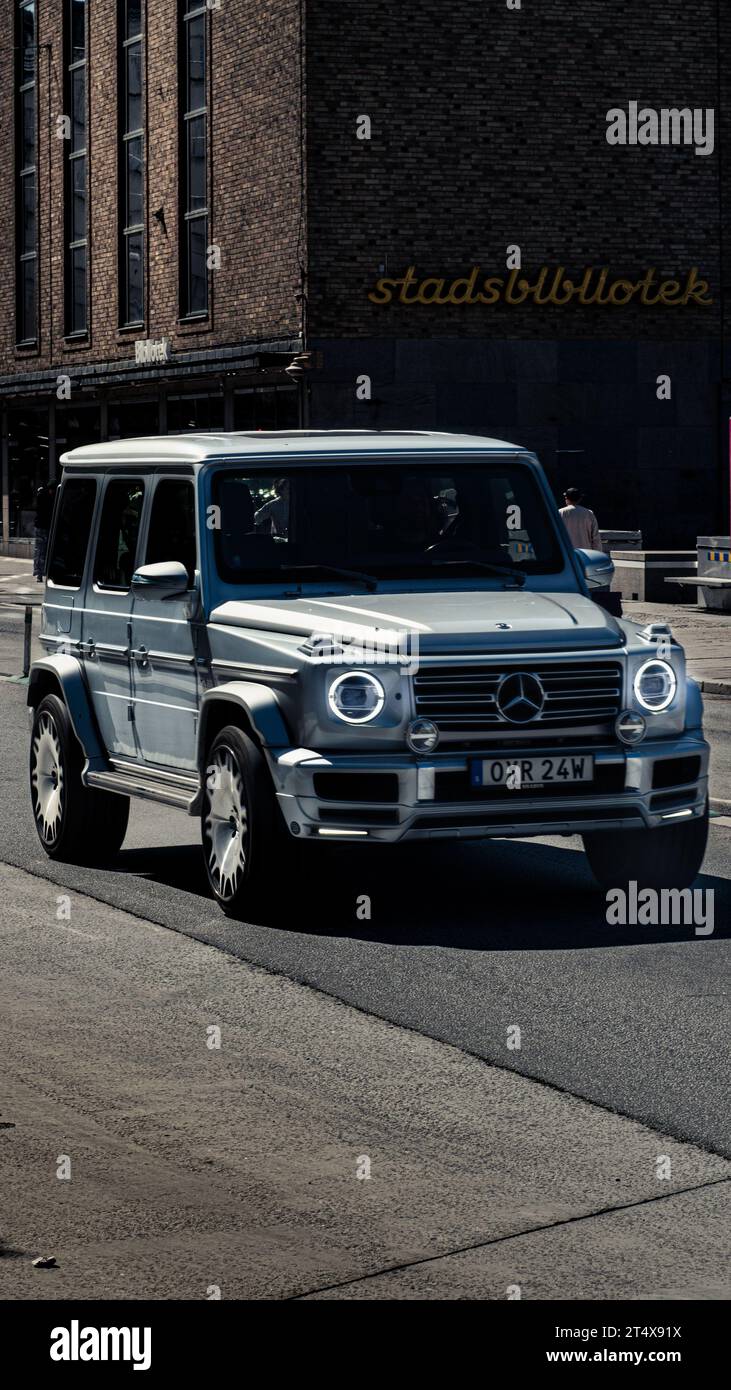 Tuned Mercedes Benz G Wagon driving in Gamlastan, Stockholm, Sweden in front of Stadtsbibliotek Library. Stock Photo