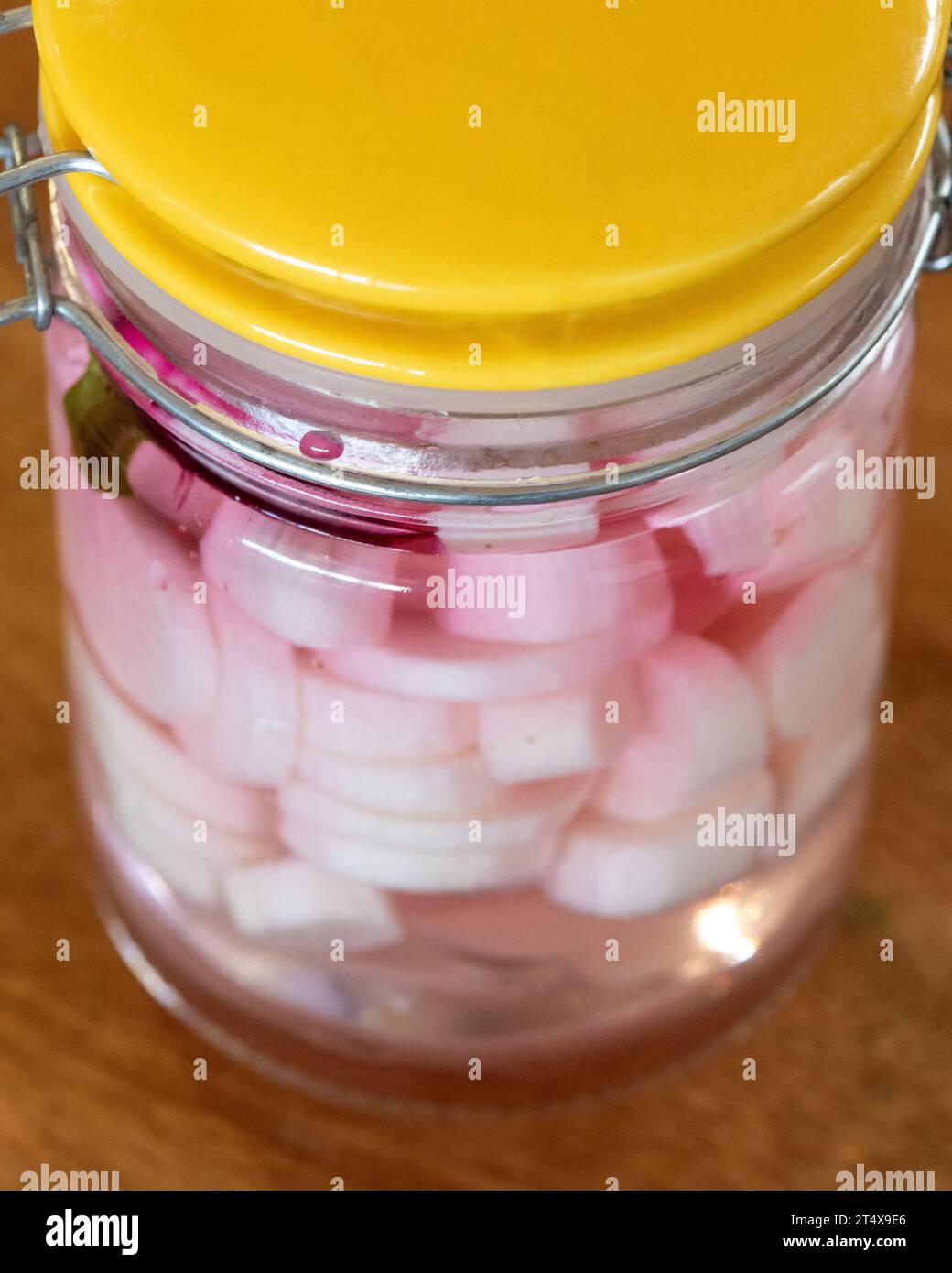 Pickled Daikon Radishes in a glass jar with a slice of beetroot Stock Photo