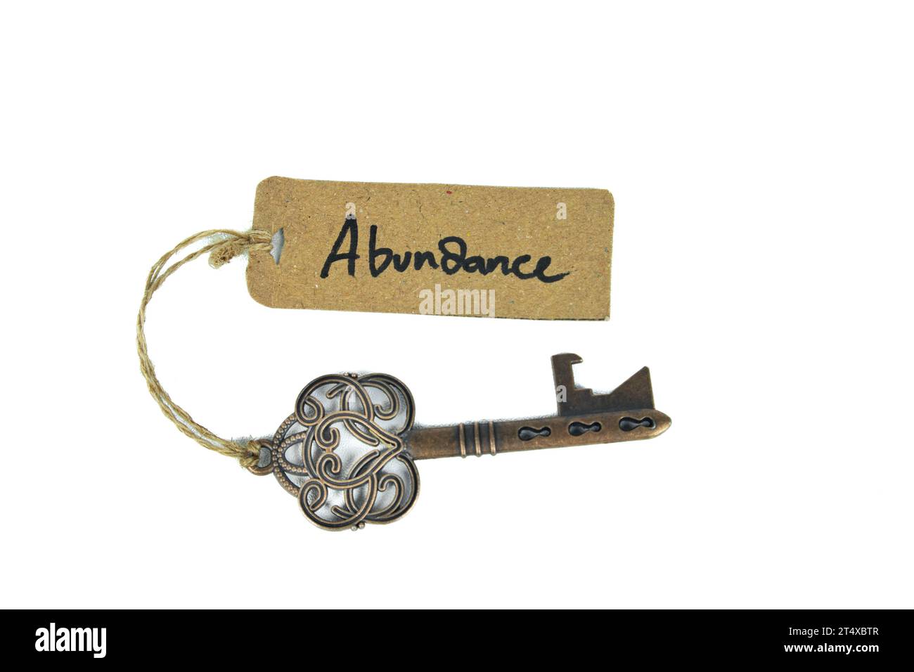 Key to abundant life concept - Old key with abundance tag isolated on white background Stock Photo