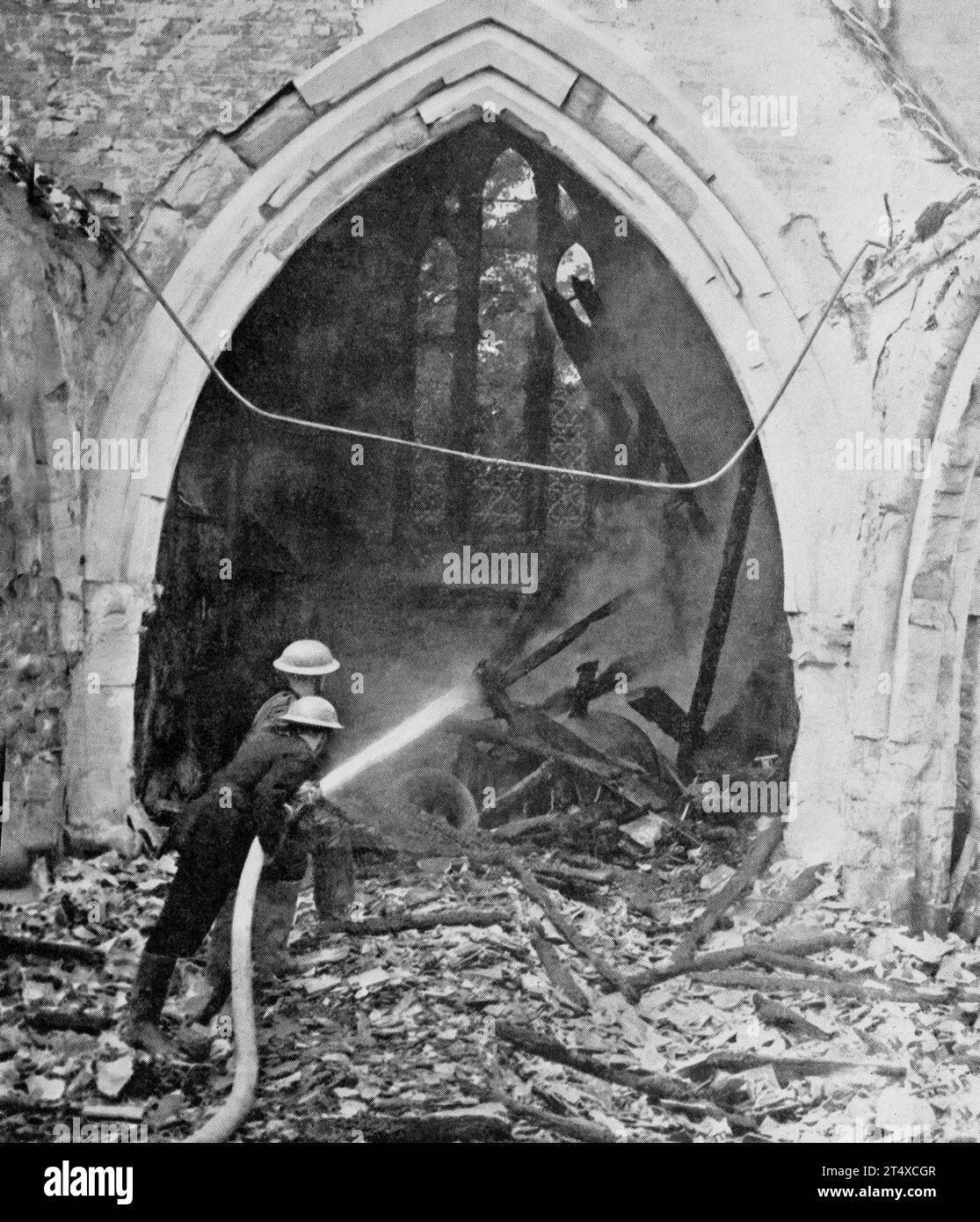 The British AFS (Auxiliary Fire Service) attending a fire caused by German incendiary bombs dropped on a church in the south of England at the end of June 1940. Stock Photo