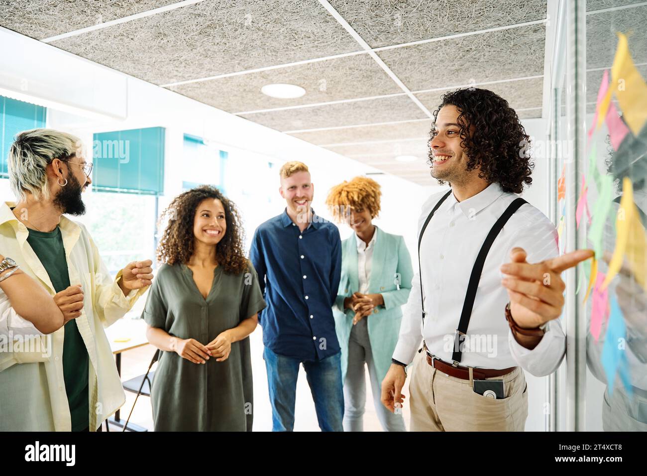 Man using post-its to explain ideas in a coworking Stock Photo - Alamy