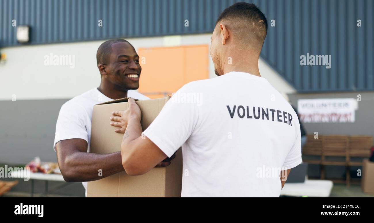 Volunteer men, helping and boxes for charity, food and clothes drive with community service for kindness. Teamwork, support and social responsibility Stock Photo