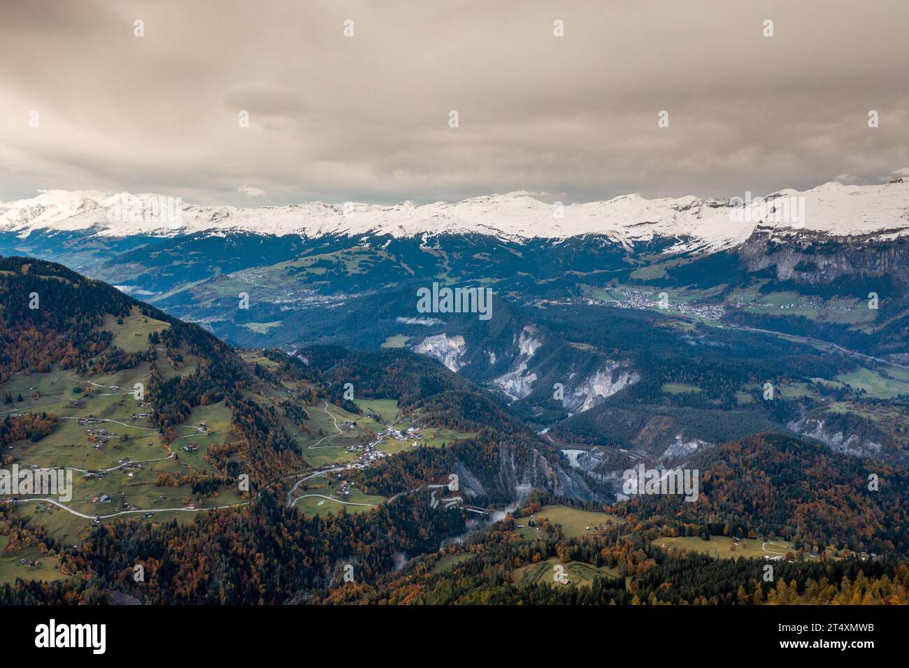 A mountain landscape in the Swiss Alps with snow-capped peaks and autum color forest Stock Photo