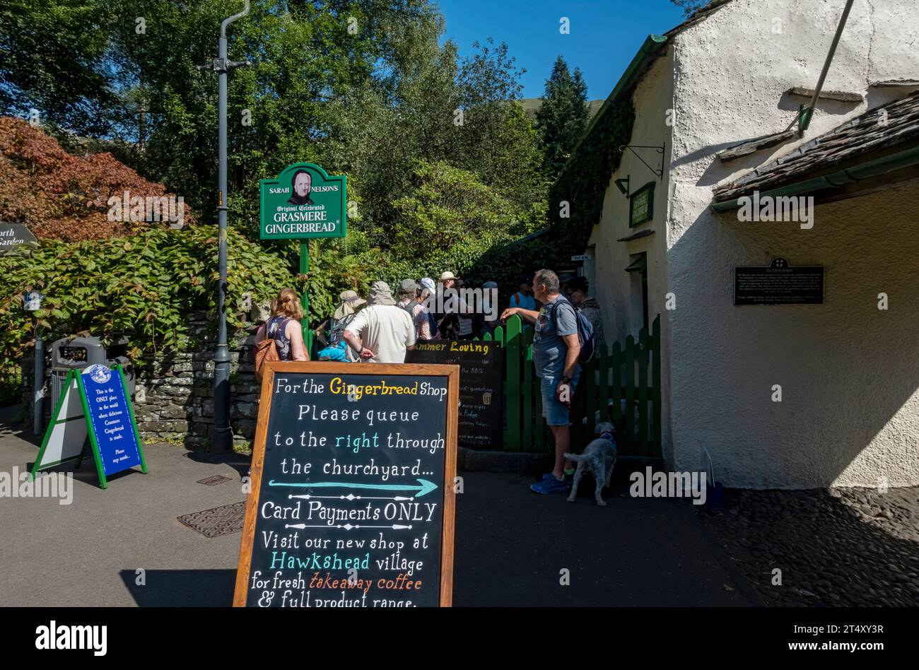 People tourists visitors queuing outside Sarah Nelson's Gingerbread cottage shop in summer Grasmere Cumbria England UK United Kingdom GB Great Britain Stock Photo