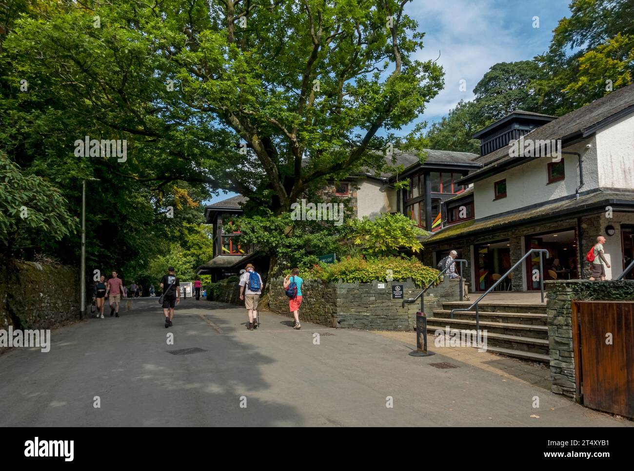 People tourists visitors walking by the Theatre by the Lake playhouse in summer Keswick Cumbria England UK United Kingdom GB Great Britain Stock Photo