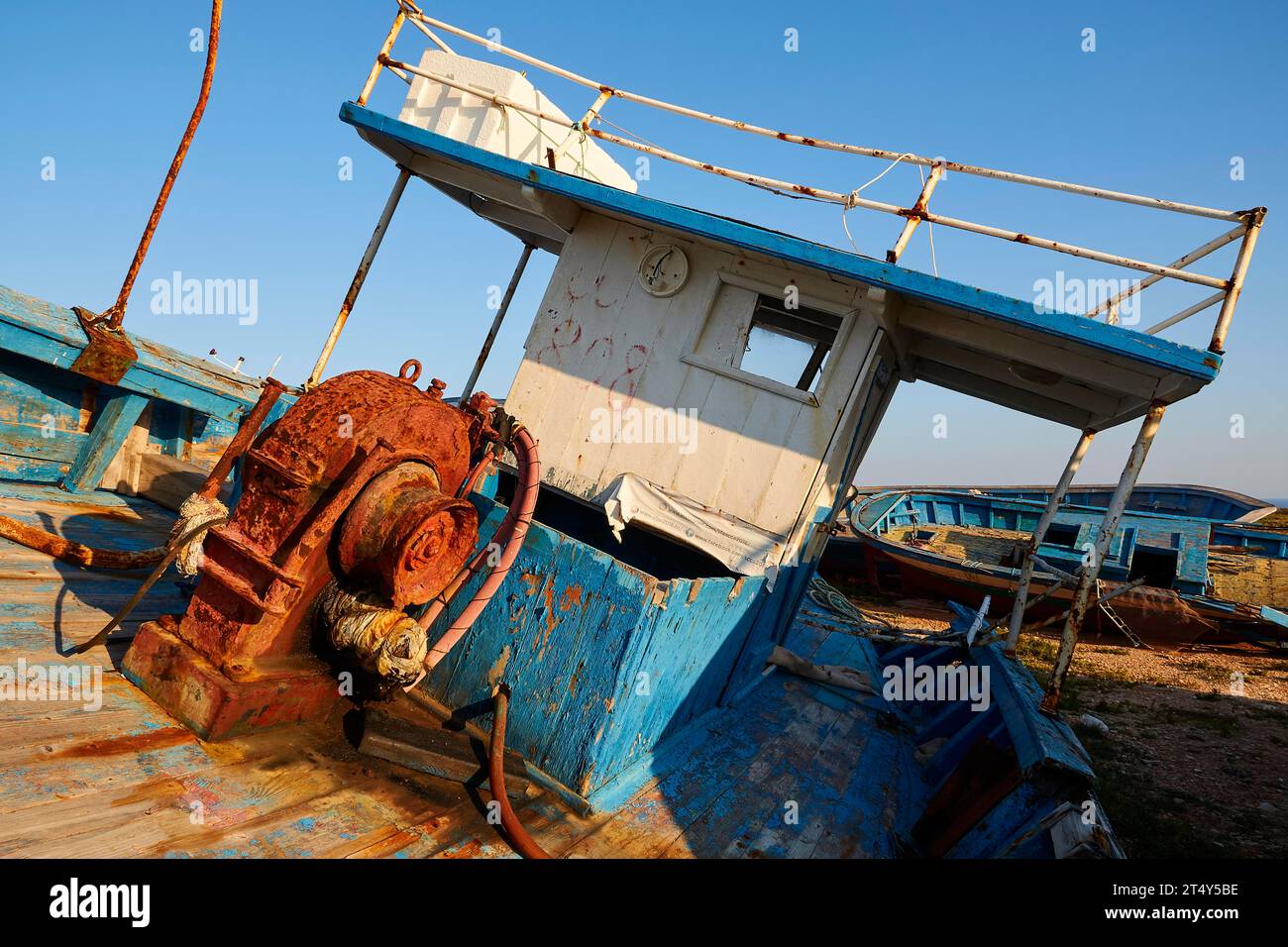 Cabin, rusted winches, details, refugee boats, Cimitero delle barche, boat graveyard, boat wrecks, cloudless blue sky, Lampedusa Island, Agrigento Stock Photo