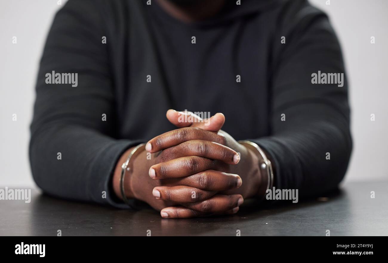 Criminal, handcuffs and table for arrest, interrogation or questions in