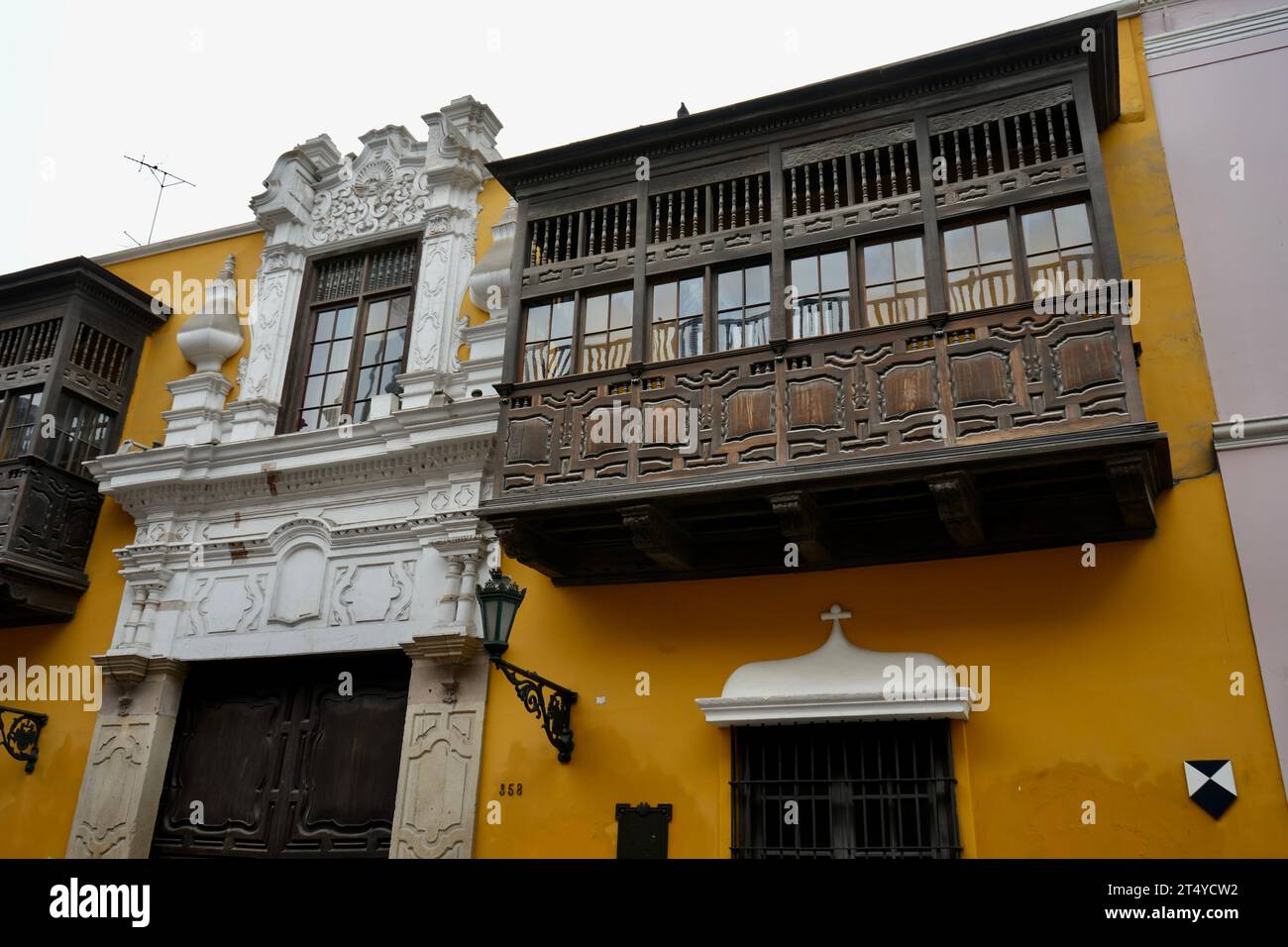 Traditional Carved wooden balcony on a yellow building. Lima, Peru. Stock Photo