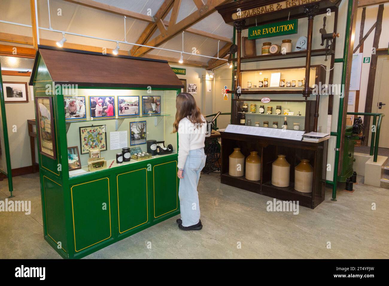 Girl child / kid / kids / children visiter look at display inside interior of the Jam Museum at Wilkin & Sons Limited in Tiptree, Essex, UK. (136) Stock Photo