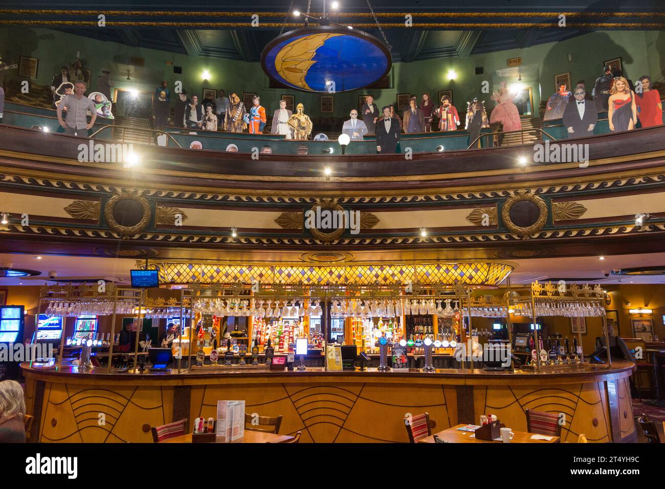Circle seating & mannequins above bar inside The Playhouse Wetherspoon pub, Colchester. Public